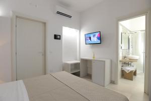 ポルト・チェザーレオにあるFilo di Ventoの白いベッドルーム(ベッド1台、シンク付)