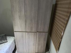 a wooden cabinet next to a bed in a room at Pousada Próximo Metro Conceição, Itaú, e Expo SP in Sao Paulo