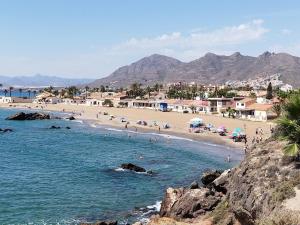 a beach with a bunch of people in the water at Capitanía frente al mar in Puerto de Mazarrón