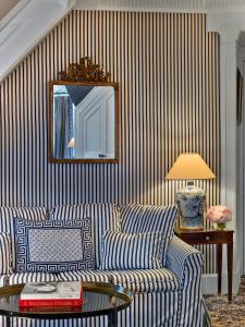 a living room with a couch and a mirror at Le Dokhan's Paris Arc de Triomphe, a Tribute Portfolio Hotel in Paris