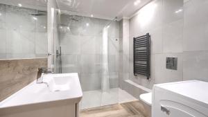 une salle de bain blanche avec un lavabo et une douche dans l'établissement Blue Baltic, Sun & Snow, à Pogorzelica 9 autres photos