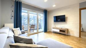 un salon avec un canapé et une télévision dans l'établissement Blue Baltic, Sun & Snow, à Pogorzelica