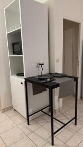a black desk in a room with a shelf at Appartement au Plessis-Robinson in Le Plessis-Robinson