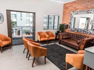 a waiting room with a couch and chairs at Leeuwenzee Guesthouse in Cape Town