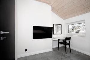 a room with a desk and a television on a wall at Apartament Świerkowy in Stronie Śląskie