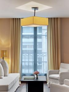 a living room with a couch and a large window at Le Metropolitan, Paris Tour Eiffel, a Tribute Portfolio Hotel in Paris