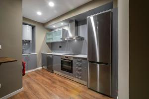 a large kitchen with stainless steel appliances and wood floors at VALERIA DREAMS-Mártires 3ºB in Zaragoza