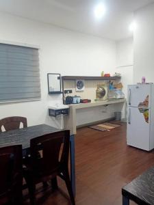 a kitchen with a table and a white refrigerator at D'semporna Homestay in Semporna