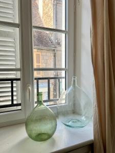 two glass vases sitting on a window sill at Chez Kiki in Felletin