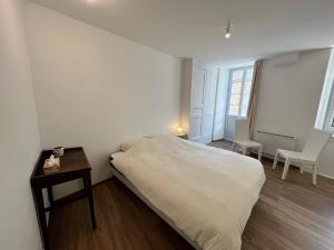 a bedroom with a bed and a table and chairs at Chez Kiki in Felletin