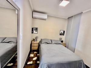 two beds in a room with a mirror at The Best in Camba Cua, A metros de la costanera y del centro de la ciudad, ubicacion inmejorable, cerca de la playa, a 2 cuadras parque Cambacua dpto moderno, completamente equipado, con balcon, con todo lo necesario para una estadia comoda y placentera in Corrientes +12 photos