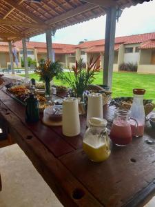 a wooden table with plates of food on it at Pousada Vila da Mata - Canastra in São João Batista do Glória
