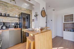 a kitchen with a wooden island in a room at Le Rooftop - A 10min de Bordeaux centre in Talence +6 photos