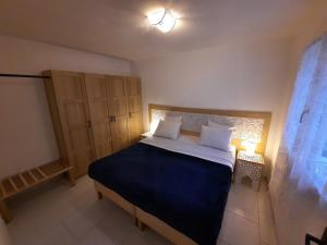 1 dormitorio con 1 cama grande con sábanas azules y almohadas blancas en Logement indépendant C & D, en Lorgues