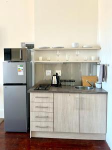 a kitchen with a refrigerator and a sink at Cosy Richmond Hill Retreat in Gqeberha