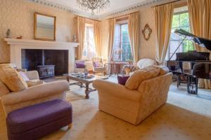 a living room with two chairs and a piano at Hockwold Hall - Former Royal residence in Hockwold cum Wilton