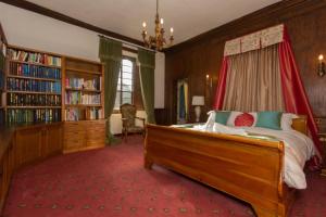 a bedroom with a bed and bookshelves at Hockwold Hall - Former Royal residence in Hockwold cum Wilton