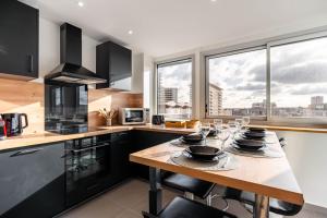 a kitchen with a table with glasses on it at Le Prouvé II - Très bel appartement climatisé in Nancy +13 photos