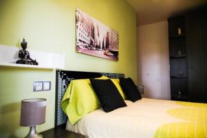 1 dormitorio con 1 cama con almohadas amarillas y negras en El Bon Pas Rural, en Boldú