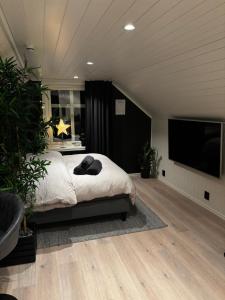 a bedroom with a bed and a flat screen tv at NY og moderne studioleilighet med elbil lading in Gjøvik