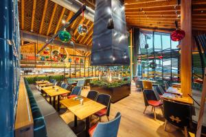 ein Esszimmer mit Holztischen und Stühlen in der Unterkunft Torfhaus Harzresort in Torfhaus