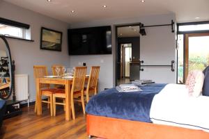 a bedroom with a bed and a table and chairs at Stylish Escape With Wood-Fired Hot Tub in Norwich