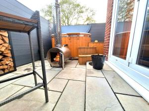 a patio with a wood fired oven on a house at Stylish Escape With Wood-Fired Hot Tub in Norwich