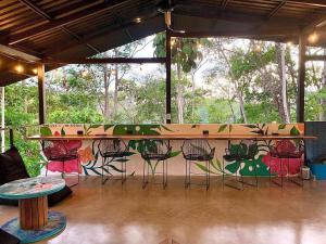 a counter with chairs and a table in a room at Shipwrecked Hostel in Uvita