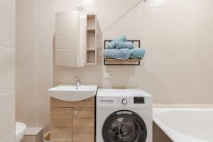 a bathroom with a washing machine and a sink at Marmor House in Rīga