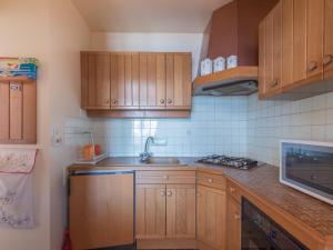 a kitchen with wooden cabinets and a sink at Les Marmottes 2 N 69 - 3P7 in Orcières +3 photos