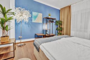 a bedroom with a bed and a blue wall at JAKSE-Apartments - Urban Jungle - top Lage & flexibler Checkin in Bochum