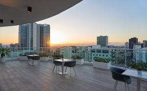 a rooftop patio with tables and chairs on a building at Armonia 24 suites by Yellowkey in Los Prados
