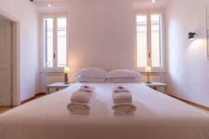 a bedroom with a white bed with towels on it at Terrazza Minerva in Rome