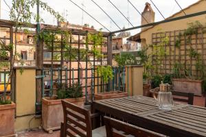 a patio with a table and chairs and plants at Terrazza Minerva in Rome