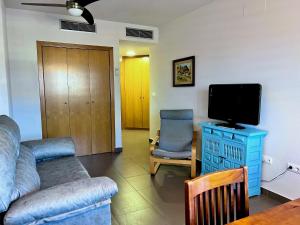 Una sala de estar con un sofá y un televisor de pantalla plana. en Apartamentos Arcos Costa Cálida, en Águilas
