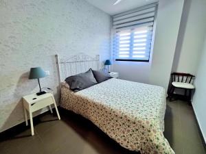 un dormitorio con una cama y una ventana en Apartamentos Arcos Costa Cálida, en Águilas