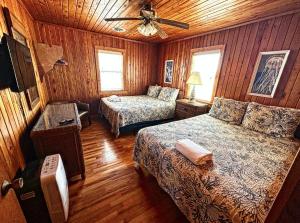 ein Schlafzimmer mit zwei Betten und einem Deckenventilator in der Unterkunft Sand Spur Cottages in Nags Head