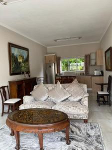 a living room with a couch and a coffee table at 3B Annie's Place Rawdons Country Estate in Nottingham Road