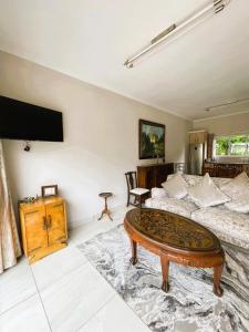 a living room with a bed and a coffee table at 3B Annie's Place Rawdons Country Estate in Nottingham Road +4 photos