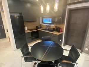 eine Küche mit Tisch und Stühlen in einem Zimmer in der Unterkunft Waikiki Apartman House with Jacuzzi in Siófok