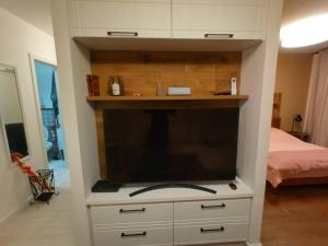 a large television in a white cabinet in a bedroom at Freedom 50 Apartman in Pécs