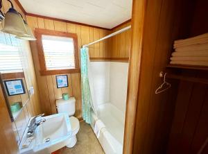 ein Badezimmer mit Waschbecken, Toilette und Badewanne in der Unterkunft Sand Spur Cottages in Nags Head
