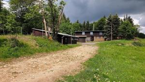 a dirt road in front of a building on a hill at SILVESTROVSKÁ HORSKÁ CHATA až pro 30 lidí in Horní Krupka