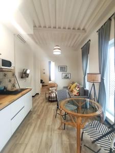 a living room with a table and a kitchen at Apartamentos La Higuera by VGH in Jerez de la Frontera