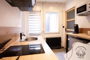 a kitchen with a sink and a counter top at Les Eugènes, appartements in Lens
