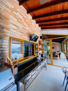 a kitchen and living room with a brick wall at Paraíso em Juquehy in Bertioga