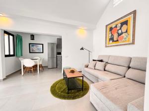 een woonkamer met een bank en een tafel bij Yumbo Rainbow Homes A in Maspalomas