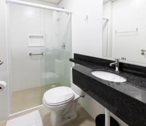 a bathroom with a toilet and a glass shower at Hotel Pitol in Balneário Camboriú +54 photos