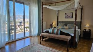 a bedroom with a canopy bed and a large window at Ephesus Suites in Selcuk