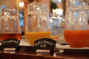 a group of four glasses of juice on plates at Hotel Postbauer-Heng, E-Mobilität, Ladestationen für Elektroautos in Postbauer-Heng